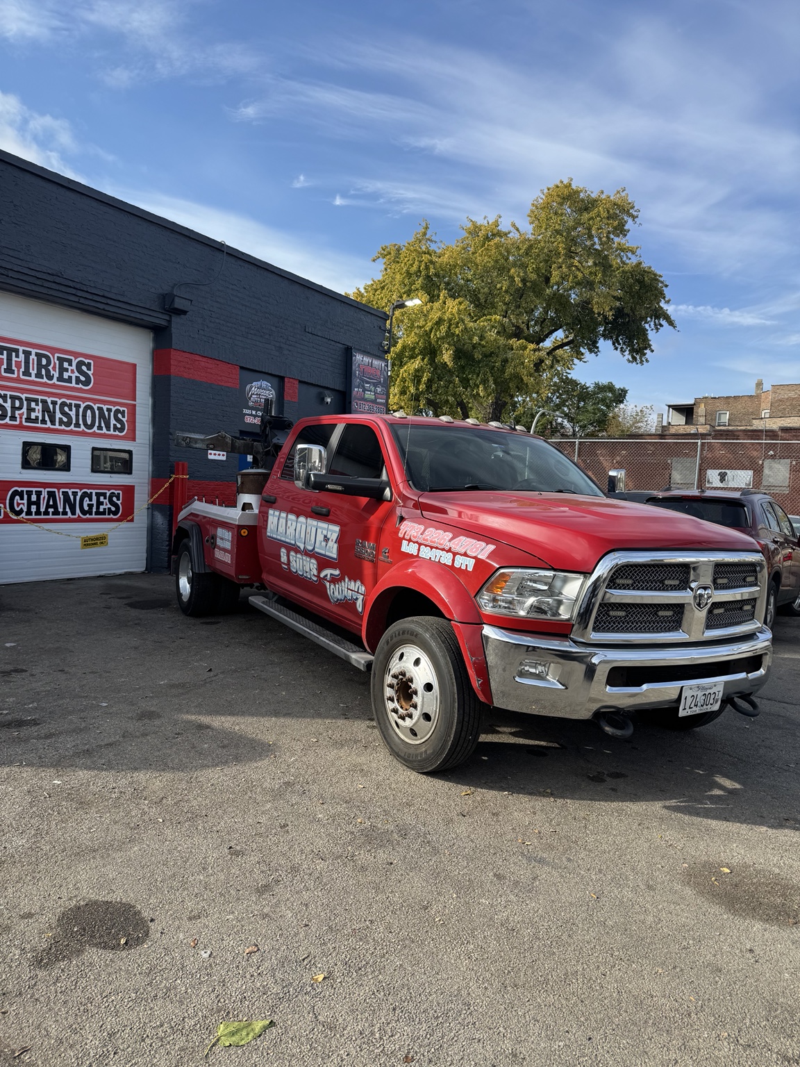 Actual red Marquez & Sons towing truck in front of the shop